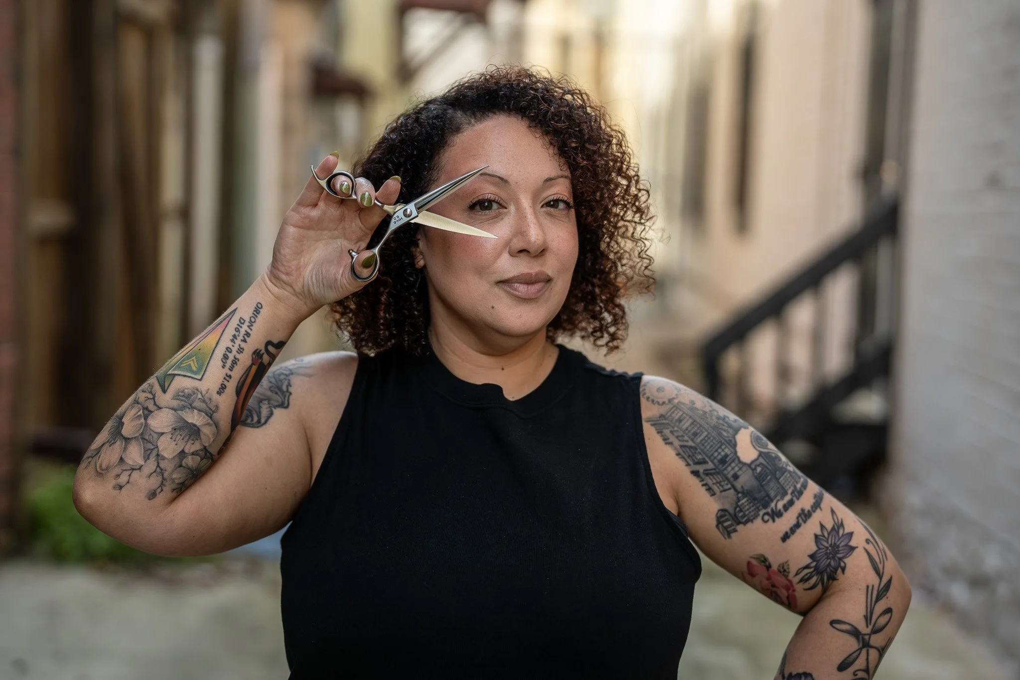 Courtney Monroe with curly hair holding scissors outdoors